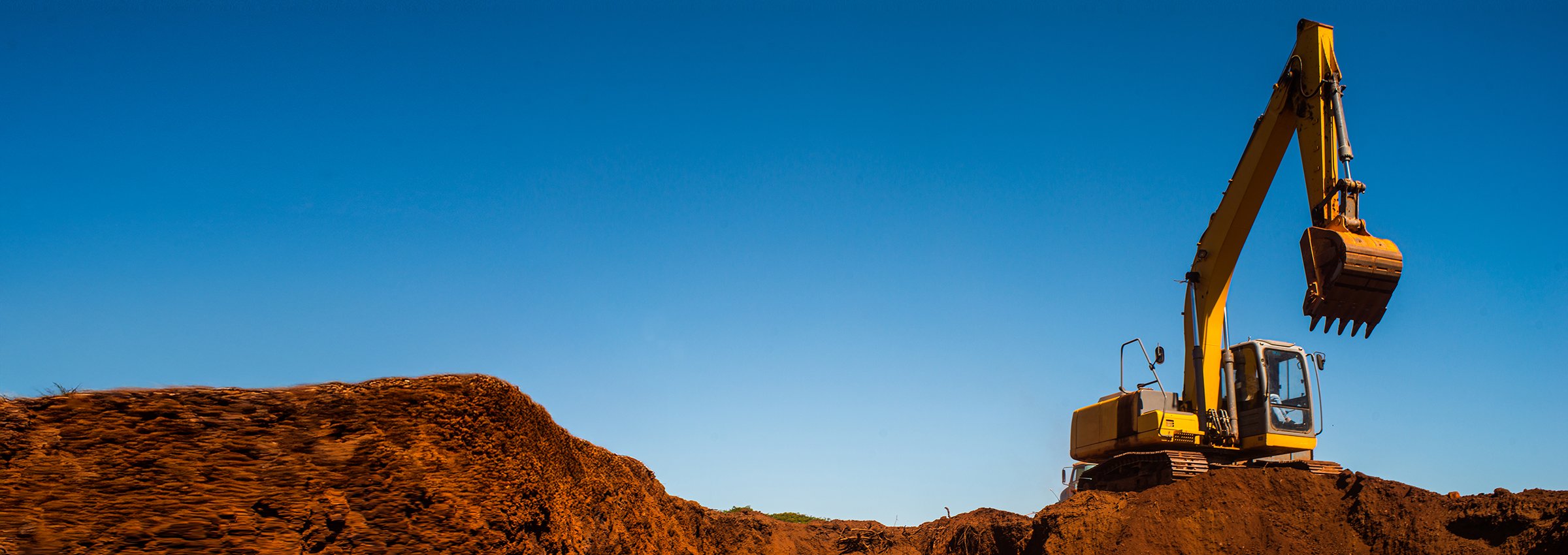 Excavator at an open-pit mine against a blue sky. Mining and Metals.